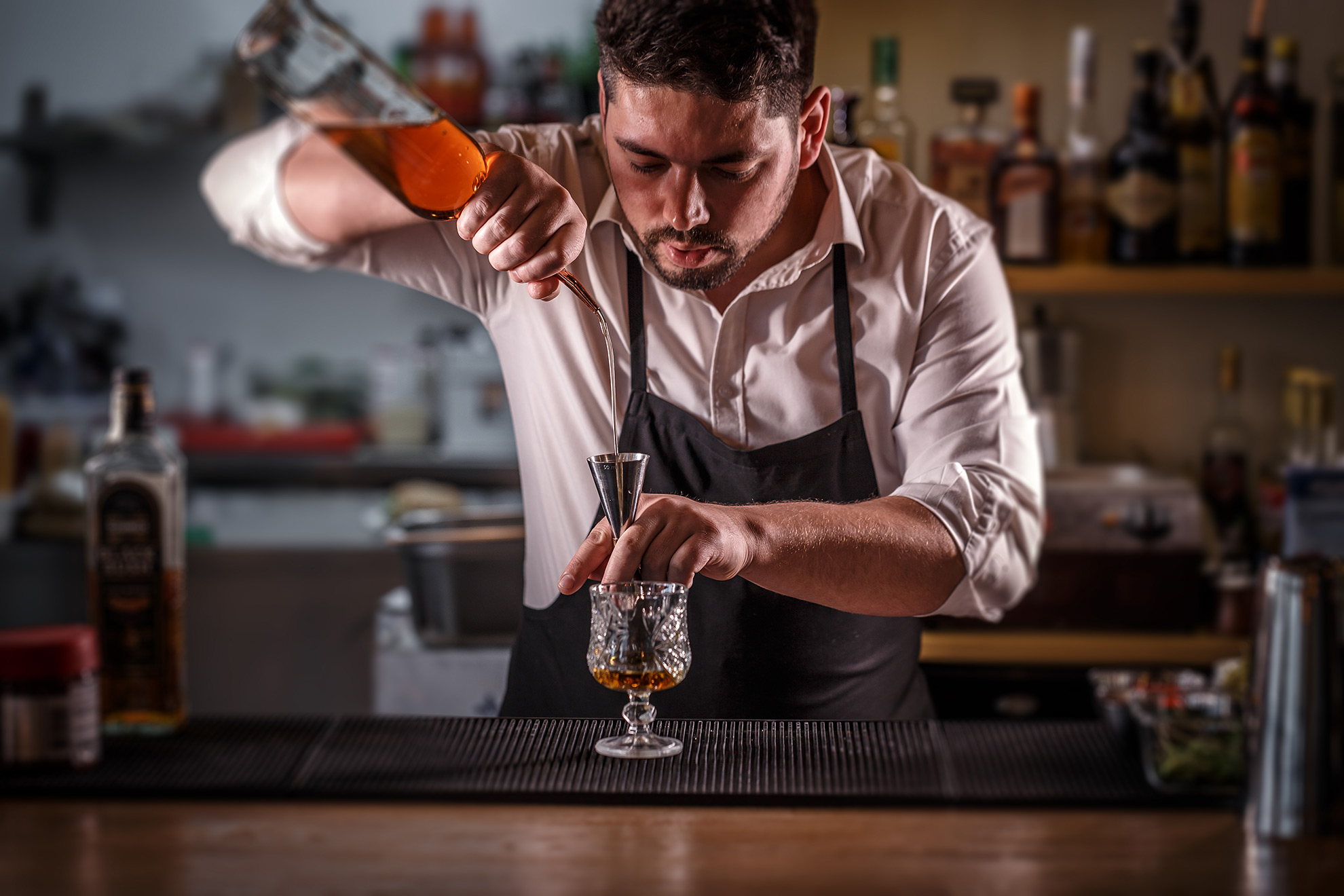 Barman nalewający alkohol za pomocą jiggera